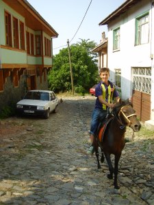 A boy rides a horse through the streets of Cumalikizik